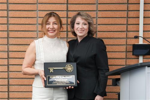 A pictured of Mrs. Marianna Gayton receiving the Key to the District from Board Clerk Mrs. Evelyn P. Dominguez 